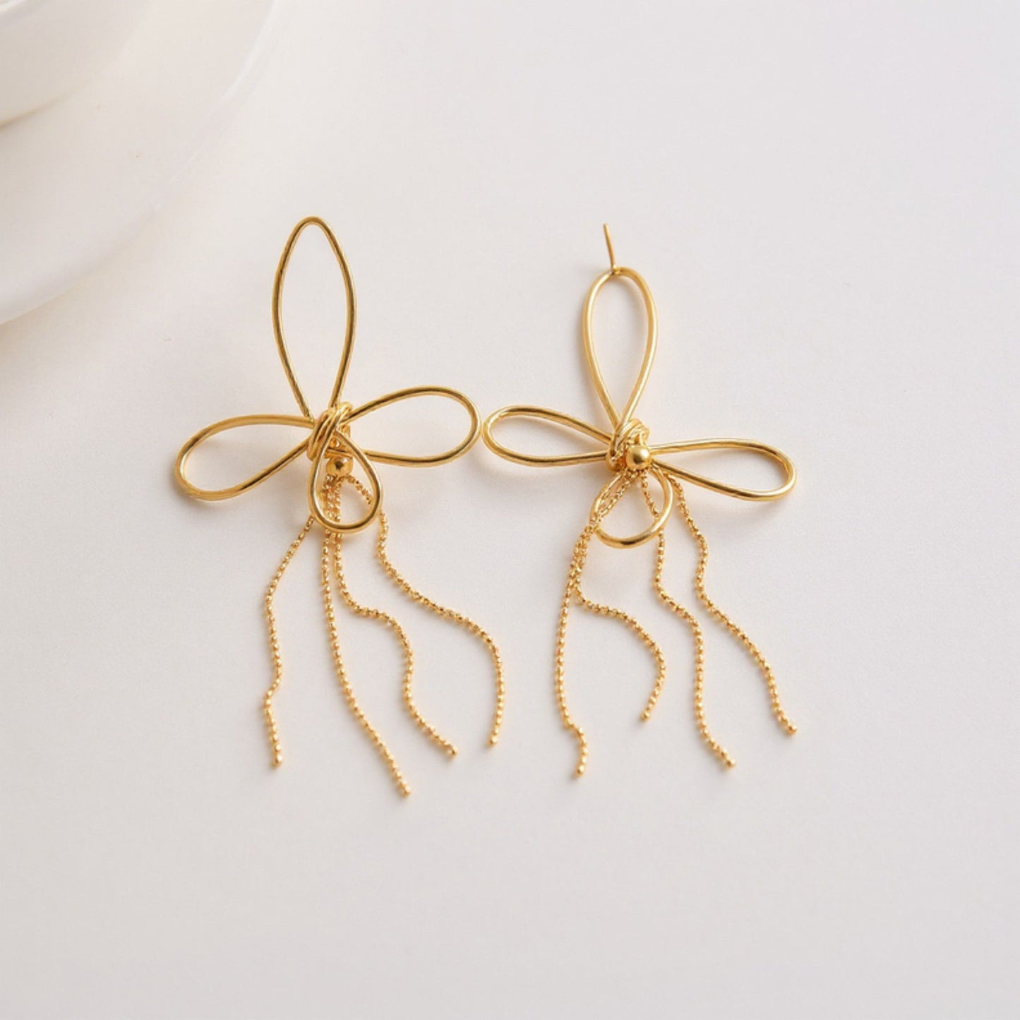 Women's Delicate Wire Bow Drop Earrings with Sculpted Loop Design and Sleek Chain Tassel Accent for Modern Elegance
