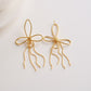 Women's Delicate Wire Bow Drop Earrings with Sculpted Loop Design and Sleek Chain Tassel Accent for Modern Elegance